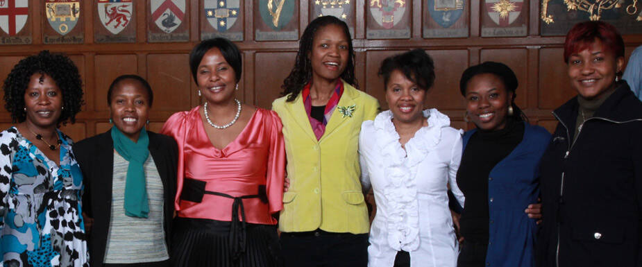 Black women gathered together with a smile on their lips